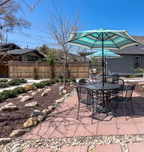 a table and chairs with an umbrella in a yard at Downtown 1 Bedroom Charmer - Walk, Bike, Enjoy!! in Rapid City