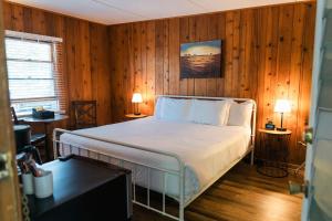 1 dormitorio con 1 cama en una pared de madera en Whispering Winds Motel, en Auburn
