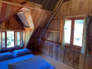a room with two beds in a wooden cabin at Vườn Nhà Củi in Da Lat