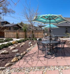 een tafel en stoelen met een parasol in de tuin bij Cozy 2 BDRM Vacation Rental - 1 Mile to Dtwn Rapid City in Rapid City