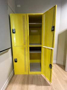 布里斯本的住宿－Banana Backpackers，房间里的一个空黄色储物柜