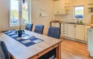 cocina con mesa y mesa de madera con sillas en Nice Home In Grbo With Jacuzzi en Gråbo