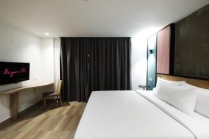 a hotel room with a large bed and a tv at The Bayou Hotel Langkawi in Pantai Cenang