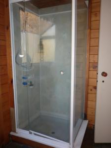 a shower with a glass door in a bathroom at A room 5 minutes' walk to the beach in Wellington