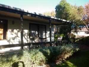 un porche de una casa con sillas en el patio en A room 5 minutes' walk to the beach, en Wellington