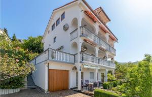 a large white house with a balcony at Cozy Apartment In Crikvenica With Heated Swimming Pool in Crikvenica
