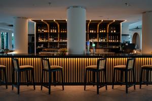 a bar with stools in front of a bar at The Bayou Hotel Langkawi in Pantai Cenang