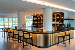 a bar in a restaurant with chairs and a counter at The Bayou Hotel Langkawi in Pantai Cenang
