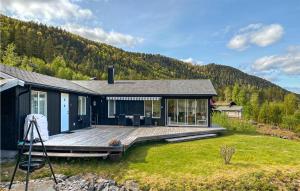 una casa con una gran terraza de madera frente a una montaña en 3 Bedroom Beautiful Home In Treungen, en Treungen