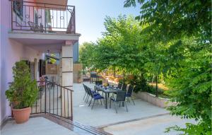 patio ze stołem, krzesłami i drzewami w obiekcie 4 Bedroom Nice Home In Krnica w mieście Krnica