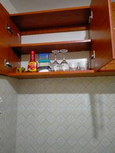 a shelf with glasses and bottles on it in a kitchen at Tranquil Homes in Nanyuki
