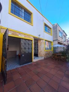 un bâtiment avec un garage et un banc devant lui dans l'établissement Makarena Hostel, à Bogotá