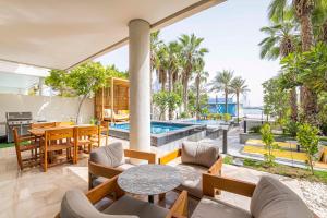 un patio extérieur avec des tables et des chaises ainsi qu'une piscine dans l'établissement FIVE PALM 3-Bedroom Villa with Private Pool, à Dubaï