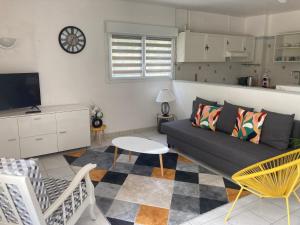 a living room with a couch and a table at Chai Saint Jean CAMELIA Piscine et SPA in Saint-Jean-de-Boiseau