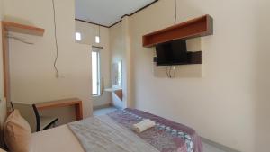 una piccola camera con tavolo e televisore di Manggasa Hotel a Makale