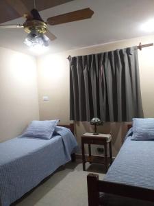 1 Schlafzimmer mit 2 Betten und einem Deckenventilator in der Unterkunft Tucuman Centro Departamento in San Miguel de Tucumán