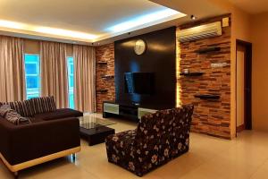 - un salon avec un fauteuil et une télévision dans l'établissement KLCC Luxurious 2 Floors Homestay 5BR for 15pax, à Kuala Lumpur