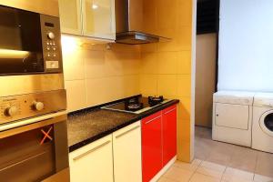 Il comprend une petite cuisine équipée d'une cuisinière et d'un four micro-ondes. dans l'établissement KLCC Luxurious 2 Floors Homestay 5BR for 15pax, à Kuala Lumpur