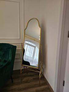 a mirror on a stand next to a green chair at Boutique Hotel Honey in Kutaisi