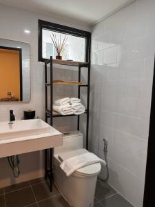 W łazience znajduje się umywalka, toaleta i lustro. w obiekcie Dado9home w mieście Klong Toi