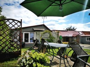 a table and chairs with an umbrella in a yard at DeBoskie Domki in Mrągowo