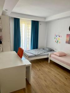 Zimmer mit 2 Betten, einem Schreibtisch und einem Fenster in der Unterkunft Feliz dia in Ştefăneştii de Jos