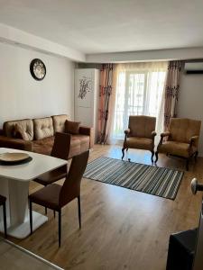 ein Wohnzimmer mit einem Sofa, einem Tisch und Stühlen in der Unterkunft Feliz dia in Ştefăneştii de Jos