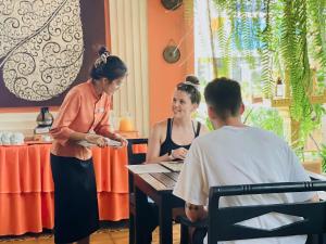 zwei Personen sitzen an einem Tisch in einem Restaurant in der Unterkunft Residence Indochine Suite in Siem Reap