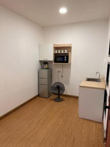 a small room with a kitchen with a microwave at Dado9home in Khlong Toei