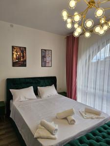 a bedroom with a large bed with two towels on it at Boutique Hotel Honey in Kutaisi