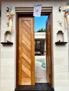 a wooden door leading to a swimming pool at Emma’s Villa in Seminyak
