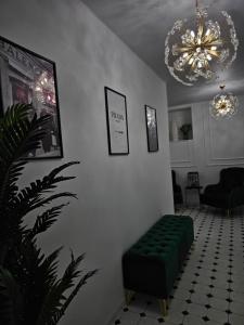 a living room with a green bench and a chandelier at Boutique Hotel Honey in Kutaisi
