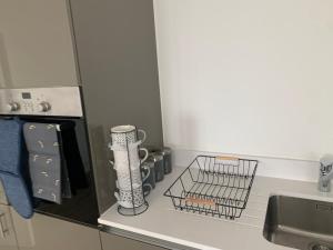 a kitchen counter with a sink and a dish rack at Next to London City airport Apartments in Woolwich