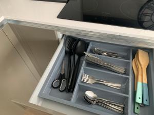 a drawer in a cabinet filled with utensils at Next to London City airport Apartments in Woolwich