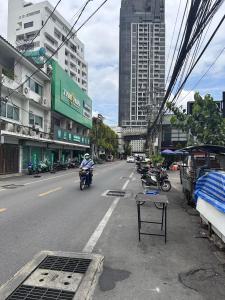a person riding a motorcycle down a city street at Dado9home in Klong Toi