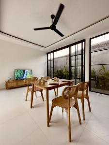 a dining room with a table and chairs and a ceiling fan at Emma’s Villa in Seminyak
