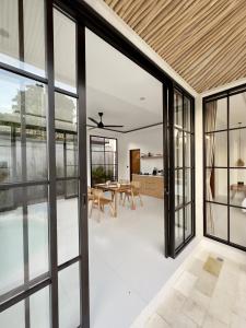 an open kitchen and dining room with sliding glass doors at Emma’s Villa in Seminyak