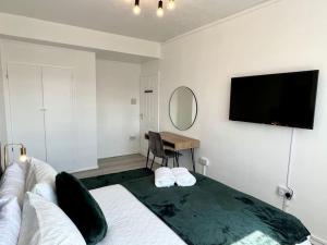 a bedroom with a bed and a flat screen tv at Lovely 3 Bedrooms Flat in London