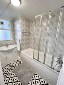 a bathroom with a shower and a tub and a sink at Lovely 3 Bedrooms Flat in London