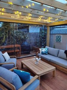 patio z kanapami, stołem i kominkiem w obiekcie Beautiful villa near everything! w mieście Christchurch