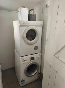 a washing machine and a washer in a room at Beautiful villa near everything! in Christchurch