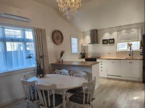 a kitchen with a table and chairs and a dining room at Beautiful villa near everything! in Christchurch