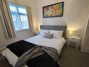 1 dormitorio con 1 cama grande y una pintura en la pared en Beautiful villa near everything! en Christchurch