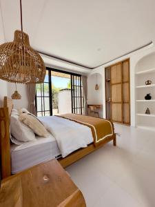 a bedroom with a large bed and a table at Emma’s Villa in Seminyak
