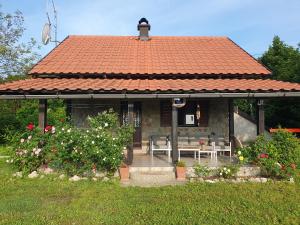 Holiday Home Modruš في Modruš: منزل بسقف احمر مع طاولة وكراسي