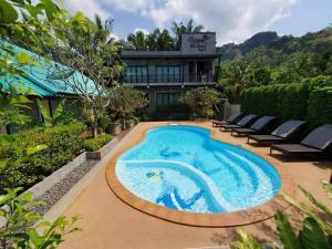 a swimming pool in front of a house at Areeya phubeach resort wooden house Coliving Coworking in Ao Nang Beach