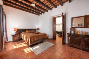 a bedroom with a bed and a dresser and a mirror at Casita La Pila in Antigua Guatemala