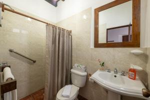 La salle de bains est pourvue de toilettes, d'un lavabo et d'un miroir. dans l'établissement Casita La Pila, à Antigua Guatemala