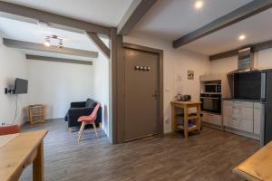 a room with a kitchen and a living room at Gîte Cascades des Tufs 2 pièces piscine in La Châtelaine