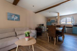 a living room with a couch and a table at Gite Cascades du Hérisson 3 chambres piscine in La Châtelaine